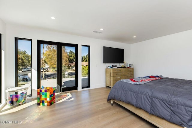 bedroom with access to exterior and light hardwood / wood-style flooring