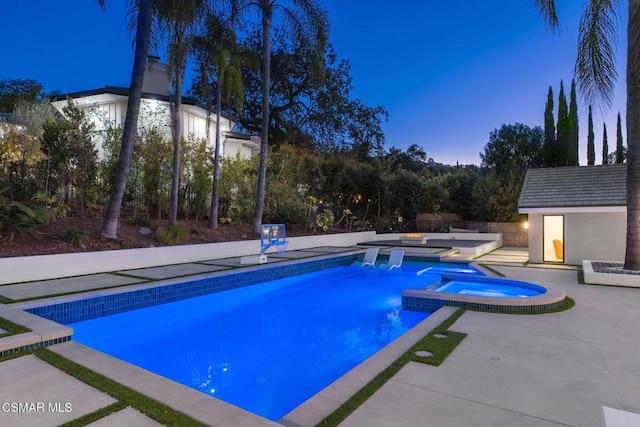 pool at dusk with an outdoor structure, an in ground hot tub, and a patio