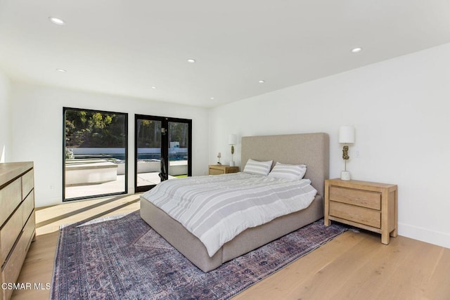 bedroom with access to exterior, french doors, and light hardwood / wood-style flooring