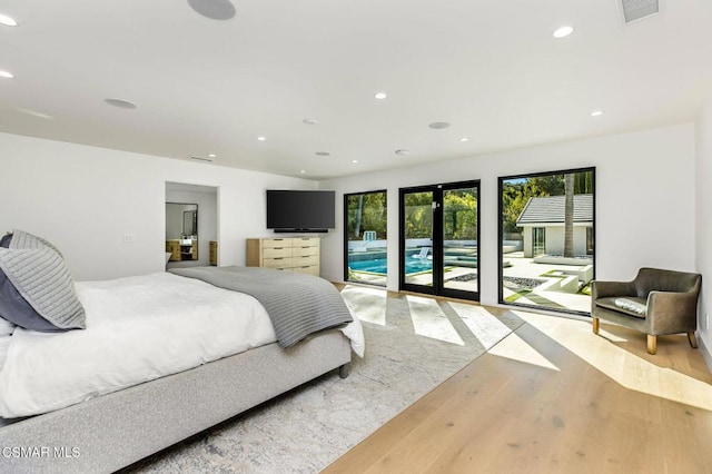 bedroom featuring access to exterior, french doors, and light hardwood / wood-style floors