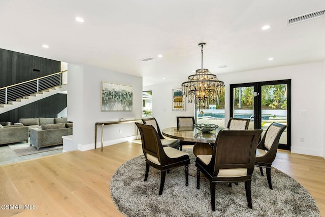 dining room with light hardwood / wood-style flooring and a notable chandelier