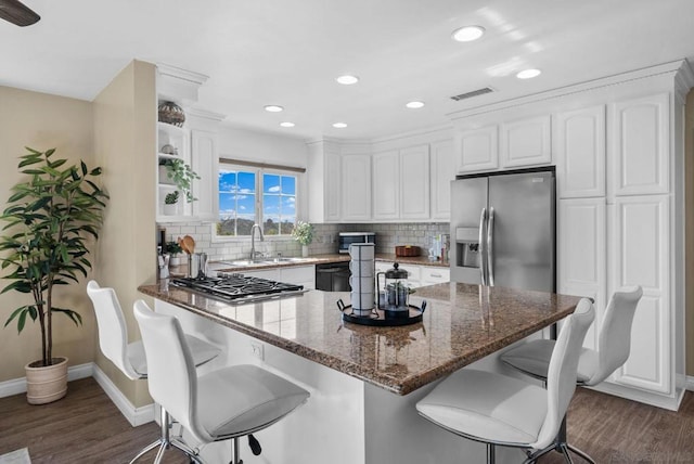 kitchen with dark stone countertops, white cabinets, and stainless steel appliances