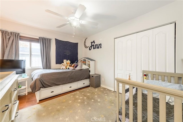 bedroom with ceiling fan, light hardwood / wood-style floors, and a closet