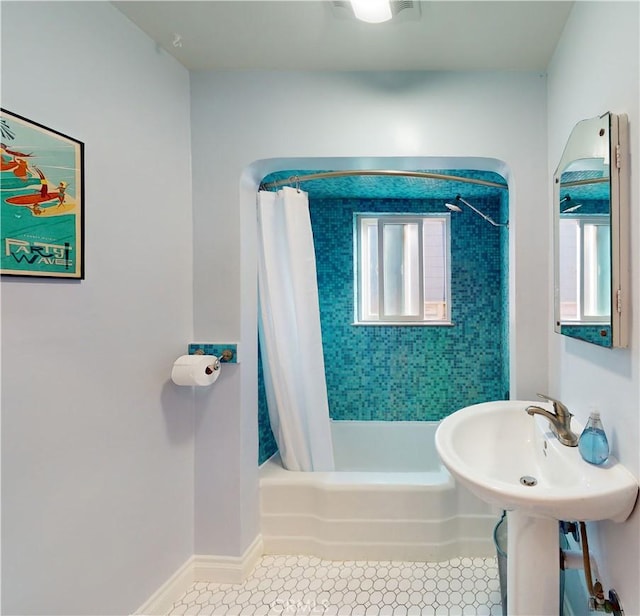 bathroom with tile patterned flooring, shower / tub combo, and baseboards