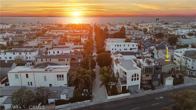 aerial view at dusk with a residential view and a water view