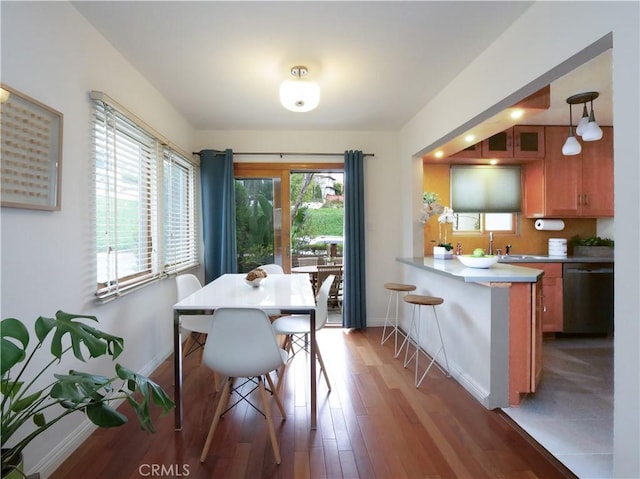 dining area with baseboards and light wood-style flooring