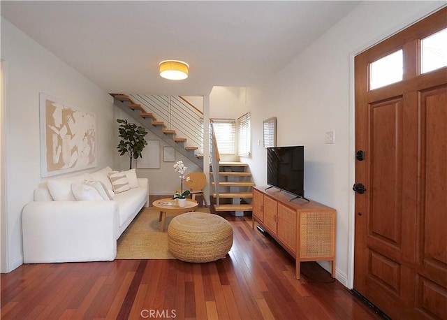 living room featuring stairs, dark wood-type flooring, and baseboards