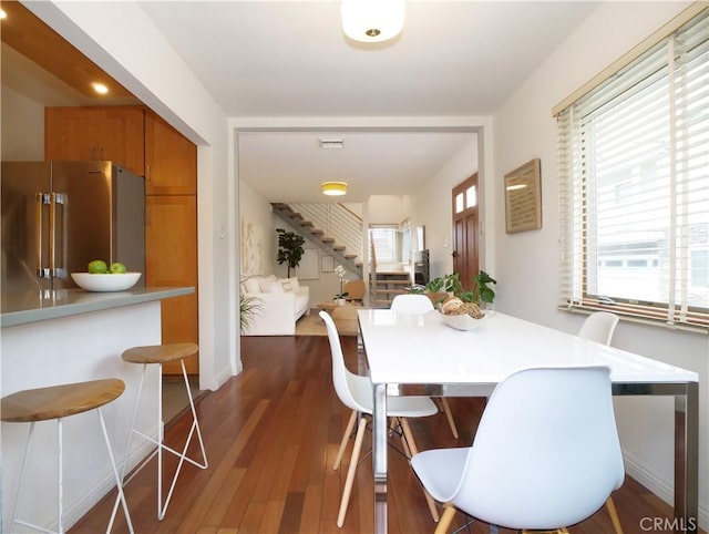 dining room featuring stairway, visible vents, and wood finished floors