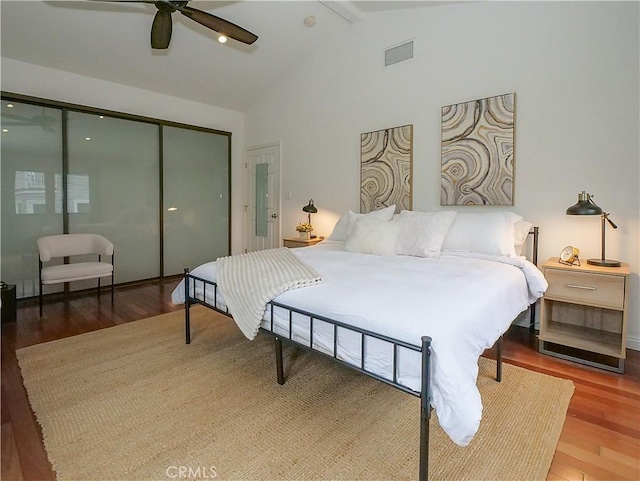 bedroom with visible vents, beamed ceiling, a ceiling fan, wood finished floors, and a closet