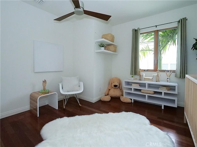 living area featuring baseboards, wood finished floors, and a ceiling fan