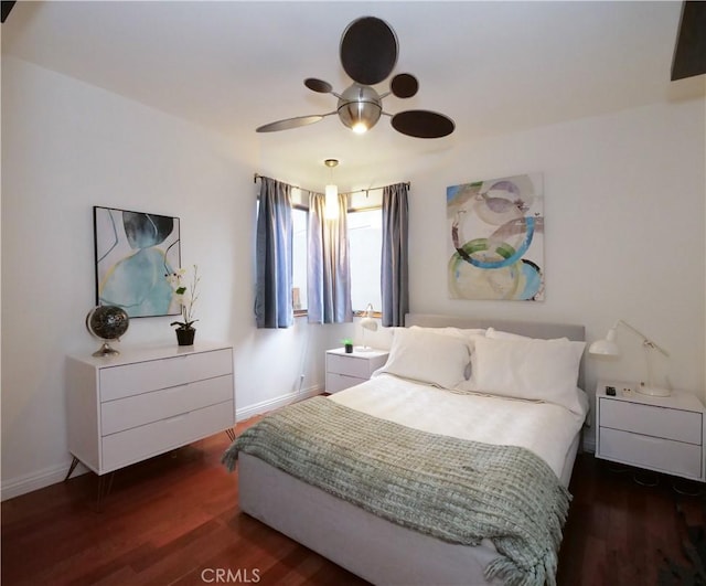 bedroom featuring ceiling fan, baseboards, and wood finished floors