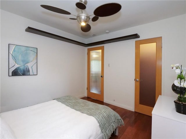 bedroom featuring visible vents, a ceiling fan, and dark wood-style flooring