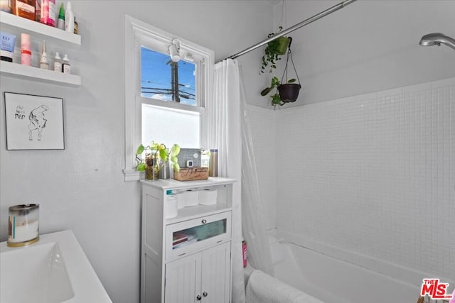 bathroom with shower / tub combo with curtain and sink