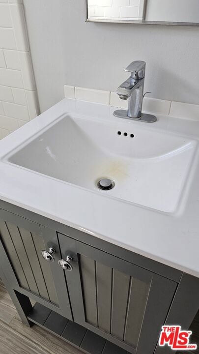 details with hardwood / wood-style floors and vanity