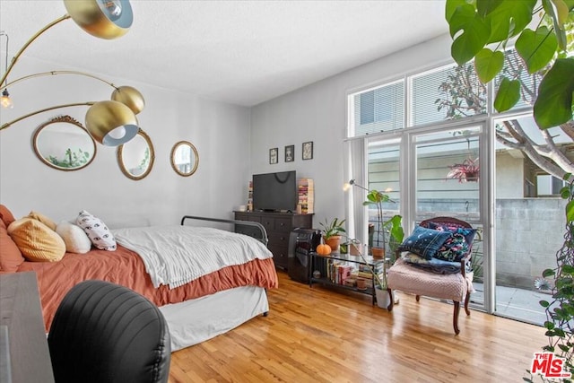 bedroom featuring access to exterior and light wood-type flooring