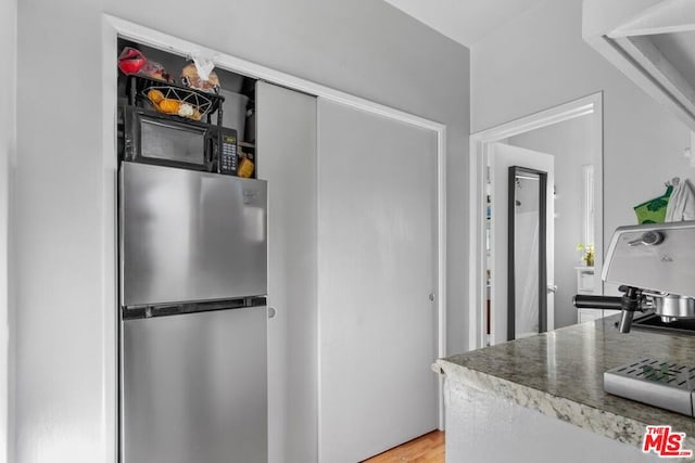 kitchen featuring stainless steel refrigerator and hardwood / wood-style floors