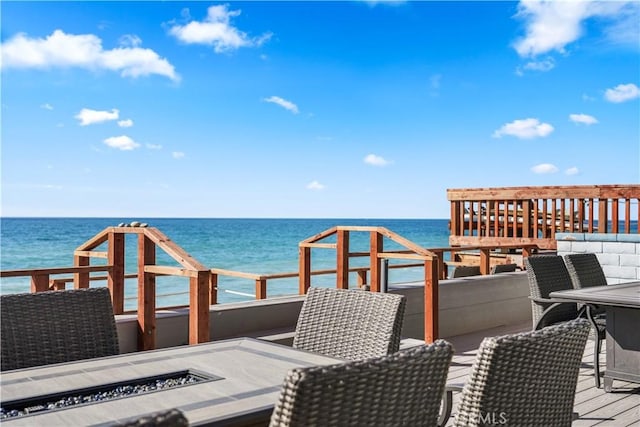 balcony featuring a fire pit and a deck with water view