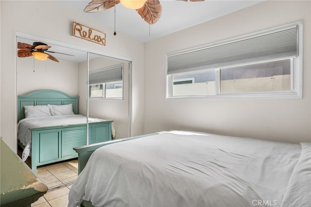 bedroom with ceiling fan, a closet, and light tile patterned floors