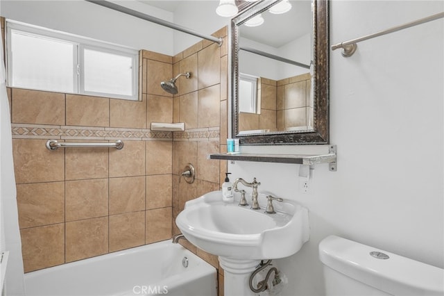 full bathroom with tiled shower / bath combo, toilet, a wealth of natural light, and sink