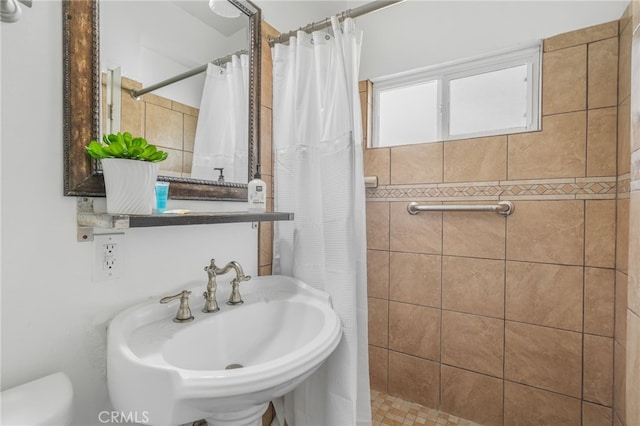 bathroom featuring curtained shower and sink