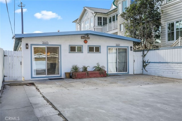 back of property with a balcony and a patio