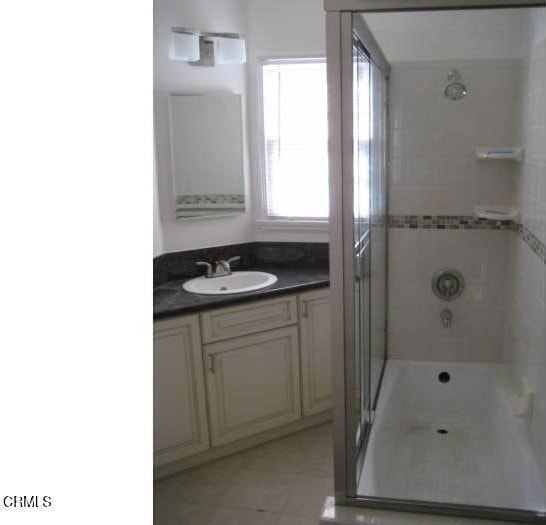 bathroom featuring vanity, tile patterned floors, and an enclosed shower