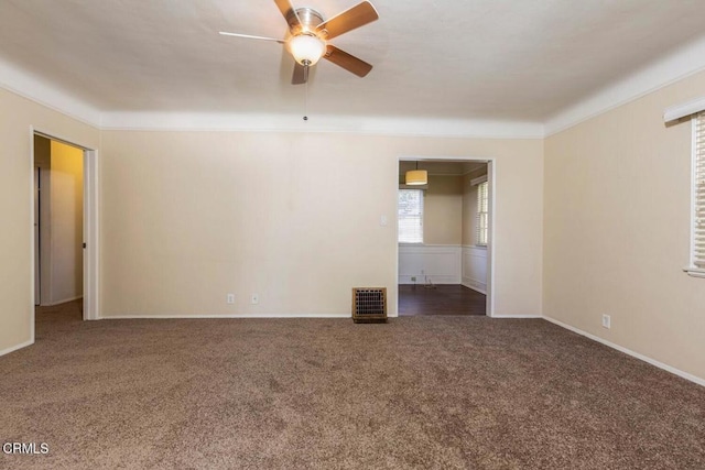 spare room featuring ceiling fan and dark colored carpet