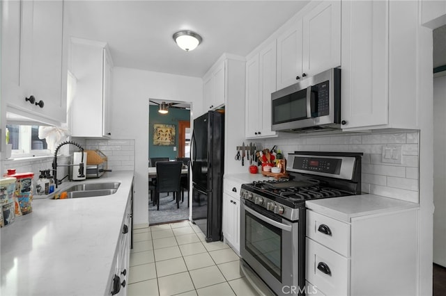 kitchen featuring tasteful backsplash, white cabinetry, sink, and appliances with stainless steel finishes