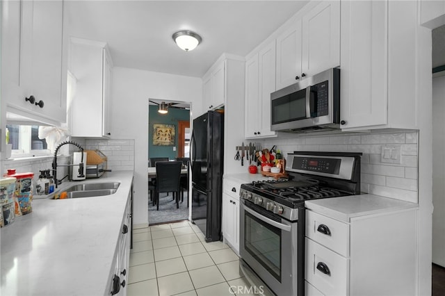 kitchen with white cabinetry, sink, light tile patterned floors, and appliances with stainless steel finishes