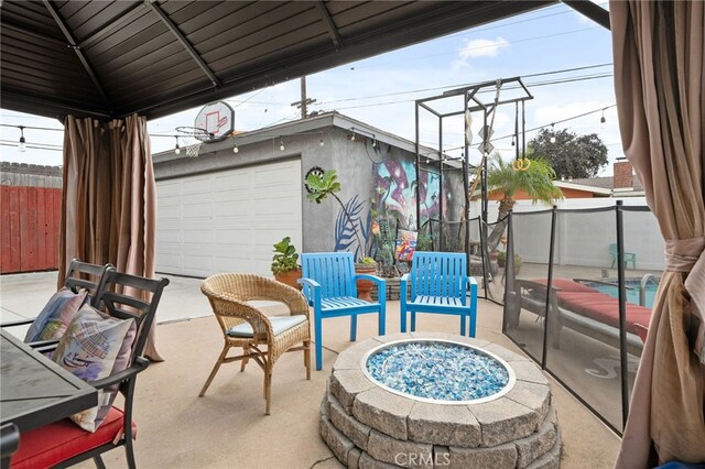 view of patio with a fire pit, a garage, and a gazebo