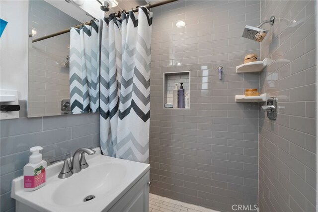 bathroom with backsplash, a shower with curtain, tile walls, and tile patterned floors