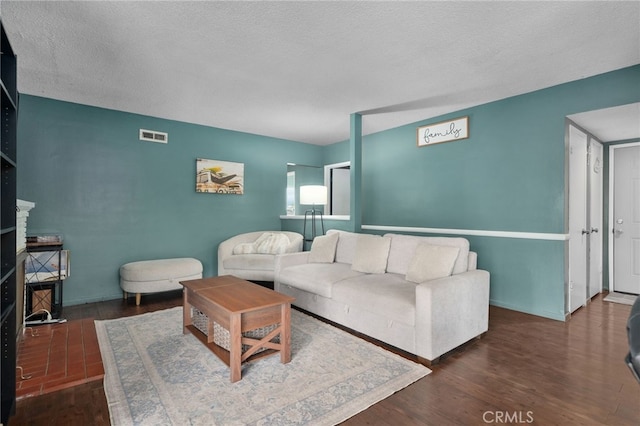 living room featuring a textured ceiling and dark wood-type flooring