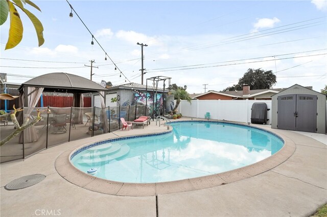 view of pool with a gazebo, a patio area, and a shed