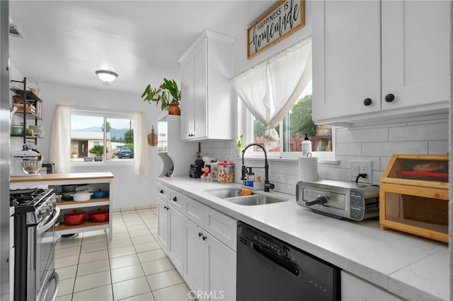 kitchen featuring sink, black dishwasher, decorative backsplash, high end stainless steel range, and white cabinets