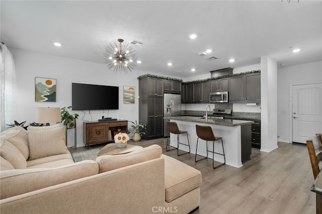 living room featuring light hardwood / wood-style floors and a notable chandelier