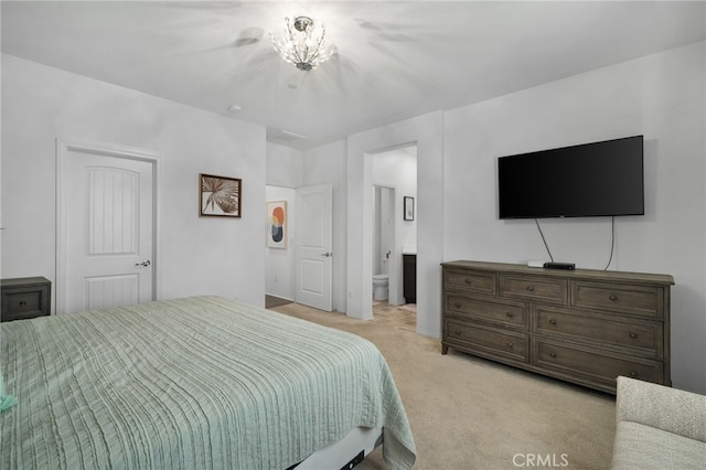 carpeted bedroom with a notable chandelier and ensuite bath