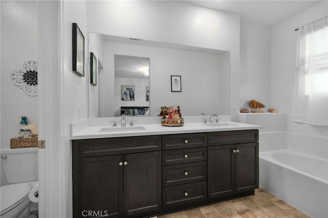 bathroom featuring a bathing tub, vanity, and toilet