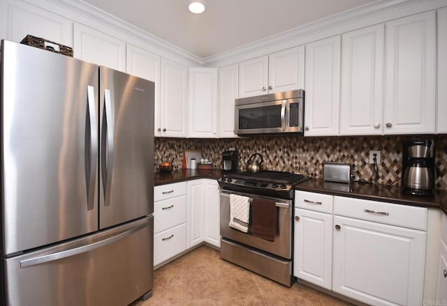 kitchen featuring tasteful backsplash, white cabinetry, stainless steel appliances, and ornamental molding