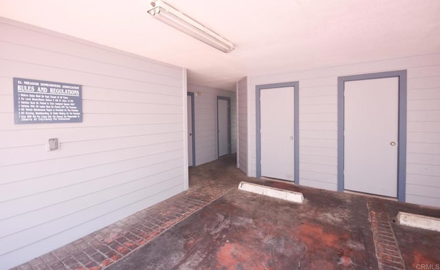 unfurnished room with wooden walls