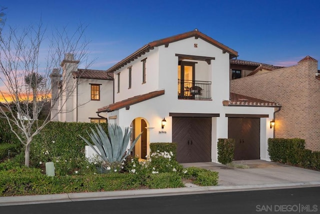 mediterranean / spanish home with a garage and a balcony