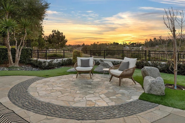 patio terrace at dusk featuring a yard