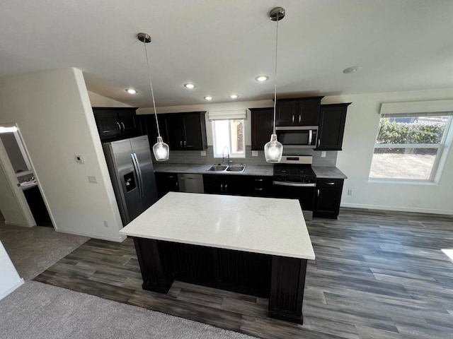 kitchen with hanging light fixtures, a center island, stainless steel appliances, and plenty of natural light