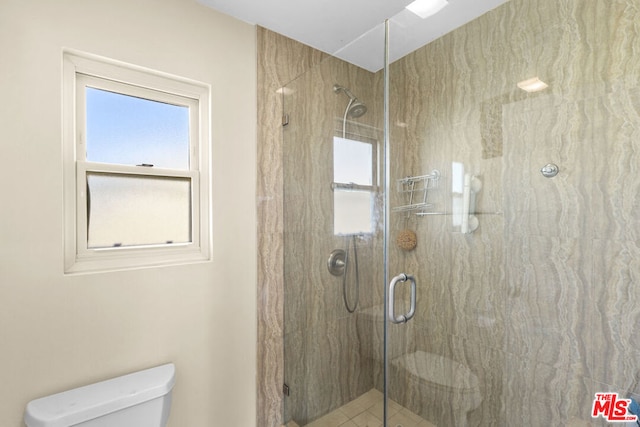 bathroom with toilet and a shower with shower door