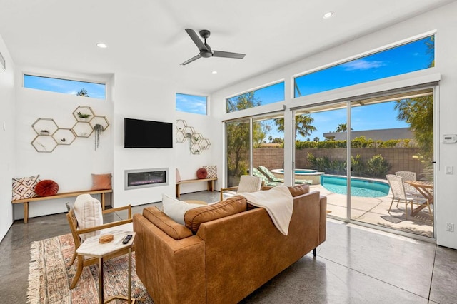 living room featuring ceiling fan and concrete flooring