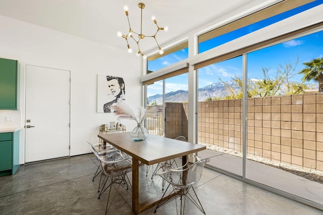 dining area featuring a mountain view, concrete flooring, and a notable chandelier