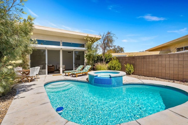 view of swimming pool featuring a patio area and an in ground hot tub