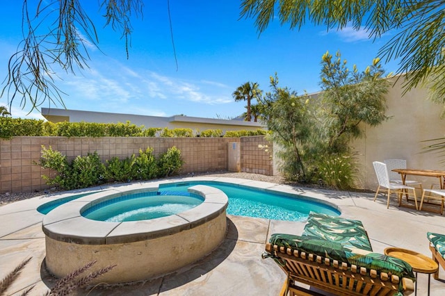 view of swimming pool featuring an in ground hot tub and a patio