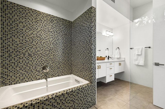 bathroom featuring tile patterned flooring, vanity, a relaxing tiled tub, and tile walls