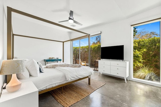 bedroom featuring ceiling fan, concrete floors, and multiple windows