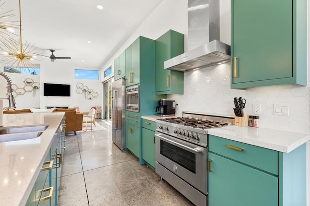 kitchen with green cabinets, high quality appliances, wall chimney range hood, and sink